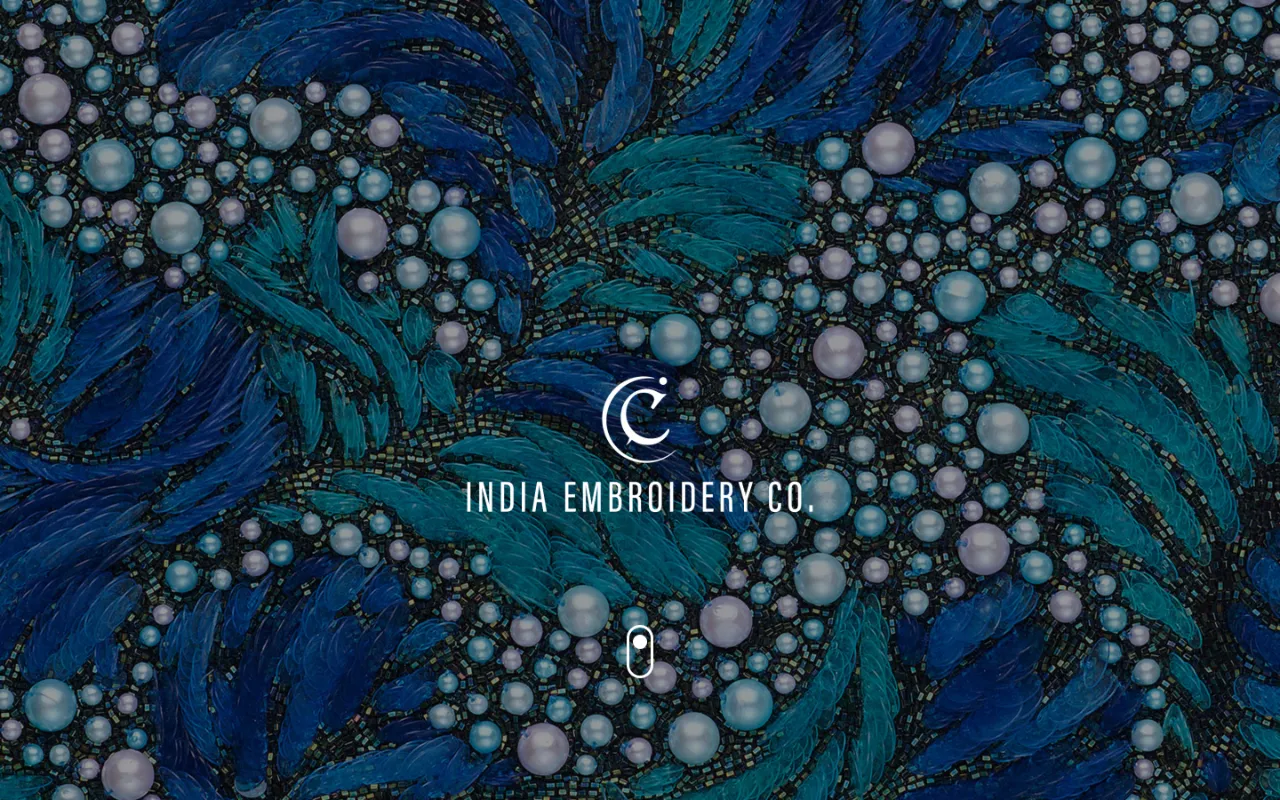 India Embroidery Co. homepage on a desktop screen: the company’s logo over a close-up of blue and teal beadwork with pearls.